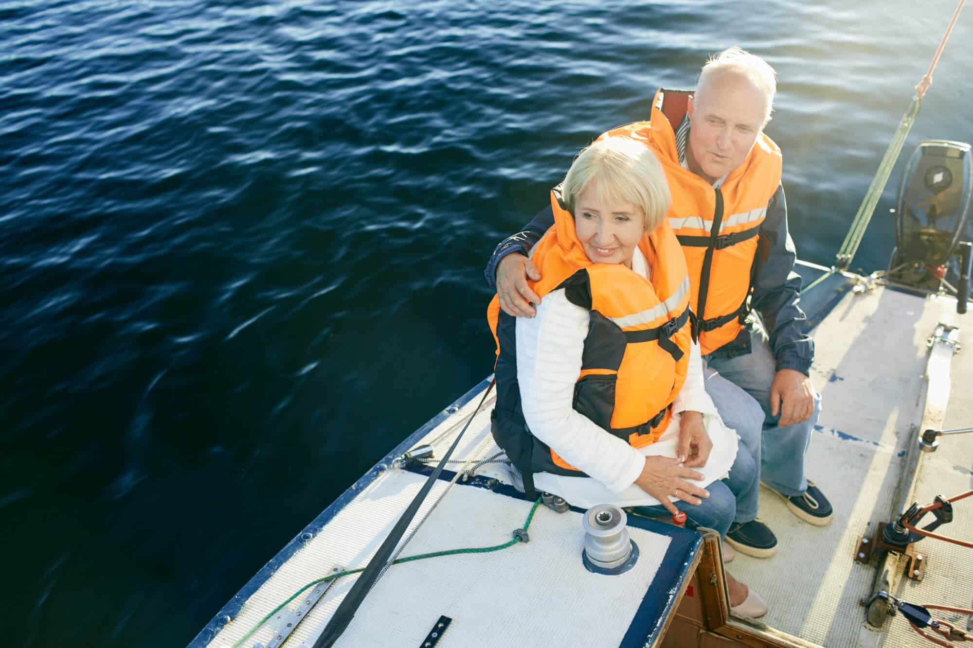 Couple sitting safely on a boat with life jackets on