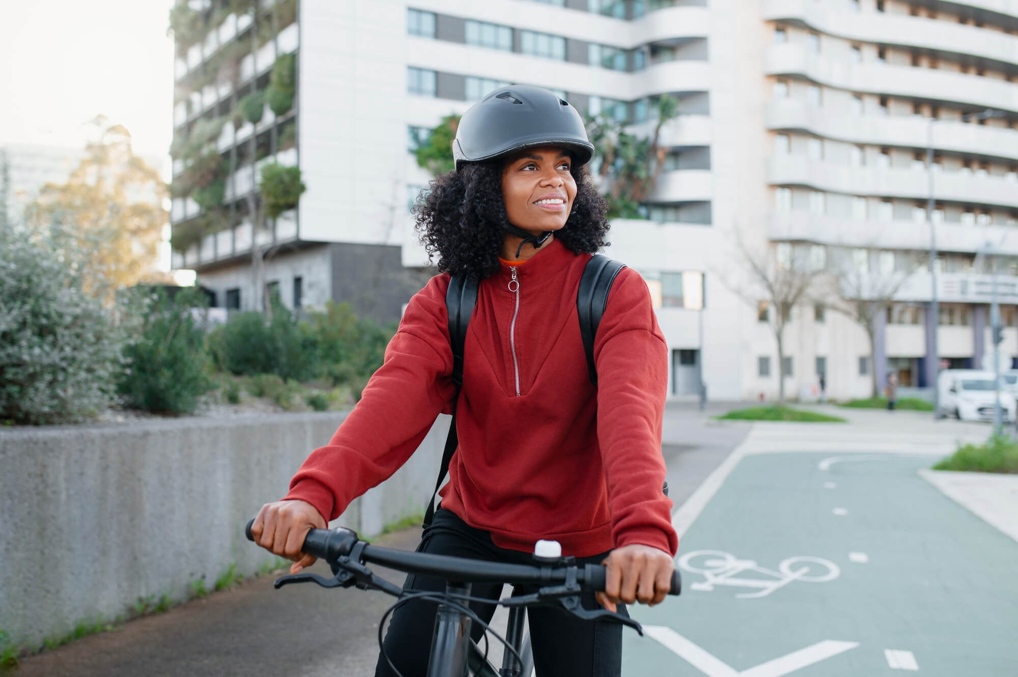 Woman riding bicycle with bicycle helmet around town