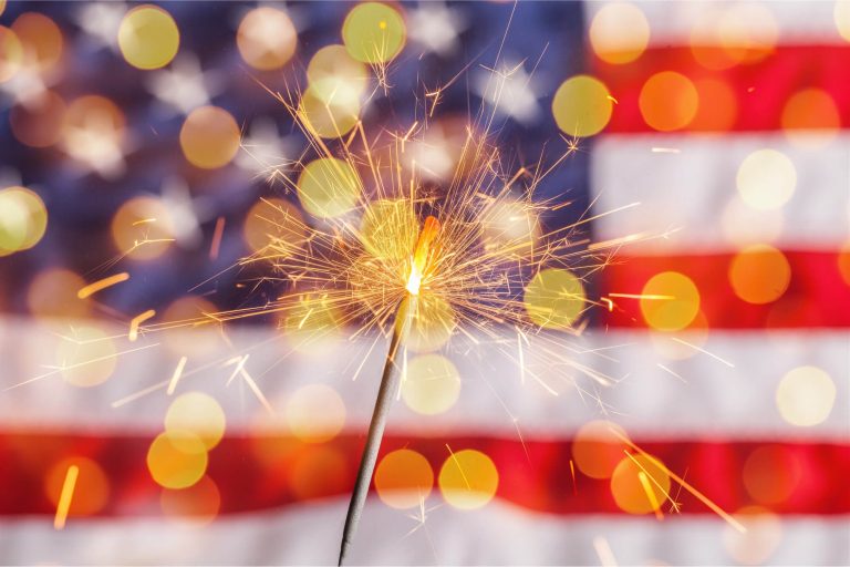 Sparkler in front of American Flag what burn related claims our personal injury attorneys have seen and how to avoid them.